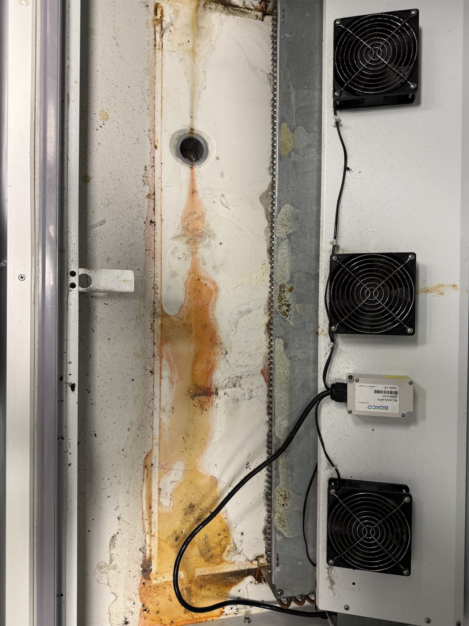Display fridge drainage — rust runoff & grime cleared — before